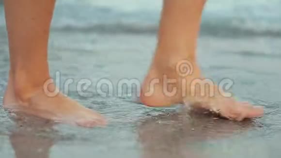 女子裸脚在海泡海滩散步特写视频的预览图