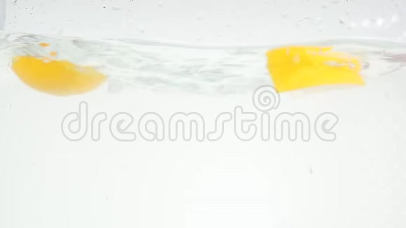 掉进水里在白色背景的慢速运动上落下橙色的切片视频的预览图