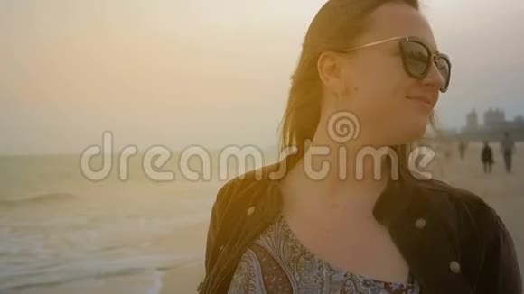 夏海海岸线上一个快乐少女的画像近距离射击视频的预览图