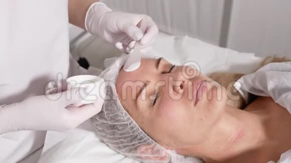 医生在他躺着的病人脸上涂了一层麻醉剂视频的预览图