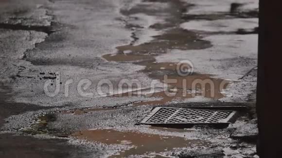 雨滴落在运动场上的水坑里倾盆大雨逼近洪水在被洪水淹没的城市街道上滴落和飞溅视频的预览图