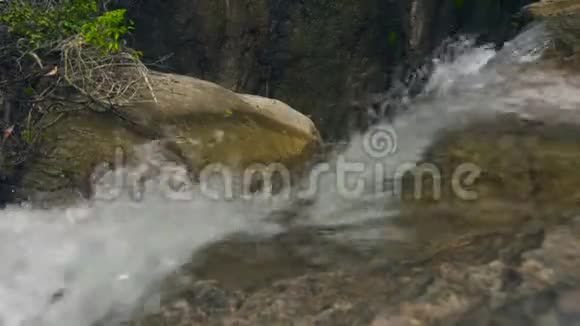 湍急的河流在热带森林中流淌大石头上的瀑布流出来的河水视频的预览图