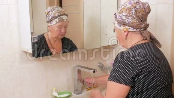 女人在洗澡时用肥皂洗脸它可以在镜盒里看到反射冲洗肥皂水视频的预览图
