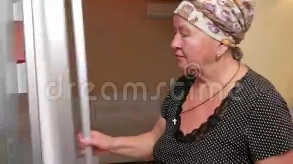 老妇人打开冰箱喝包裹里的果汁它解渴把果汁放回冰箱视频的预览图