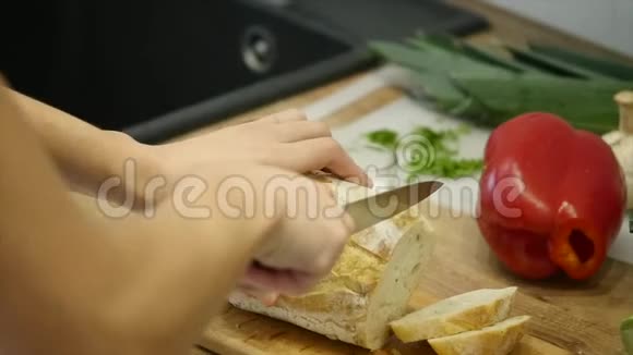 一个女人用面包刀切一条面包慢动作视频的预览图