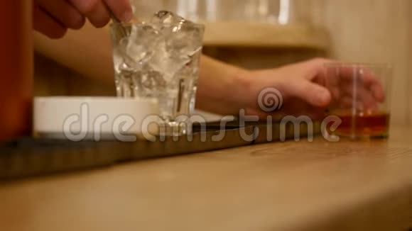 特写镜头把酒保的手倒在酒吧里端上威士忌视频的预览图