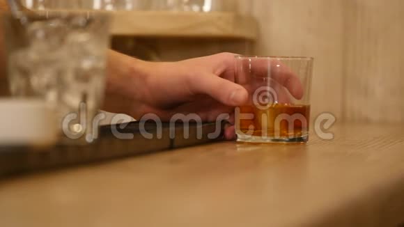 特写镜头把酒保的手倒在酒吧里端上威士忌视频的预览图