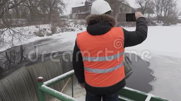 工程师在泄洪闸附近的平板电脑上拍照视频的预览图
