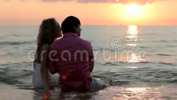 两对新婚夫妇坐在海滩上视频的预览图