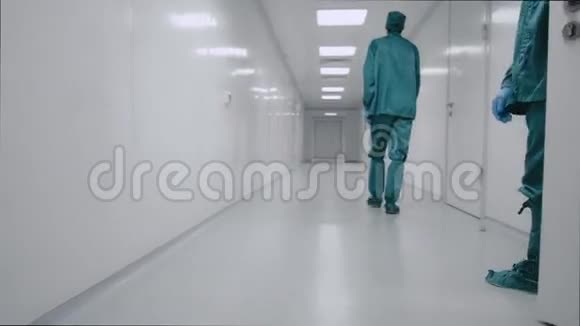 两个药剂师沿着实验室的白色走廊走着视频的预览图