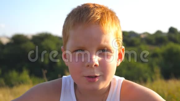 用高兴的表情掩饰男孩的情绪雀斑红发男孩快乐的画像笑了视频的预览图