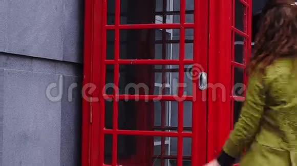 年轻的红发女人进入电话亭视频的预览图