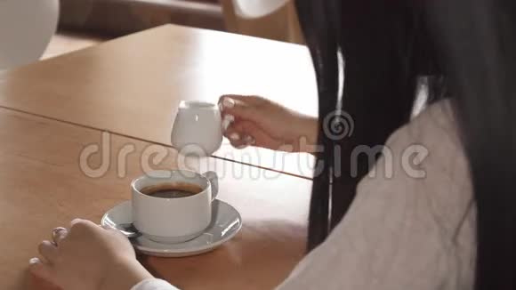 女孩在咖啡馆的咖啡里加了奶油视频的预览图