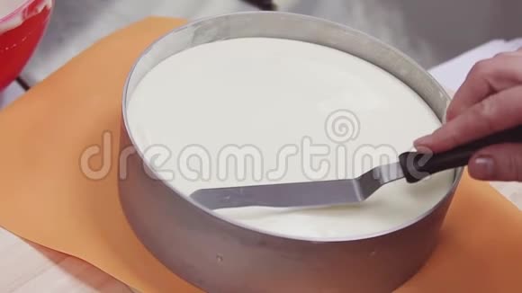 女式糕点厨师在转盘上用烤制的奶油抹刀视频的预览图