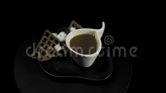 在黑色背景上有咖啡杯的彩色盘子上有一颗乌黑的心视频的预览图