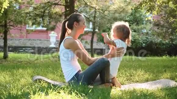 快乐的家庭年轻运动的母亲和小可爱的女儿在户外玩视频的预览图