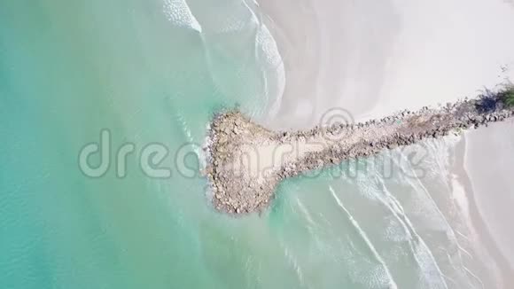 从码头上空起飞穿过一片礁石和蓝色的海洋美丽的海滩视频的预览图