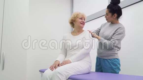 医生在诊所和一位高级妇女谈话视频的预览图