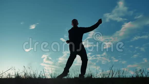 一个男人在日落时滑稽地跳舞的剪影有趣的男人笑跳舞娱乐疯狂的快乐视频的预览图