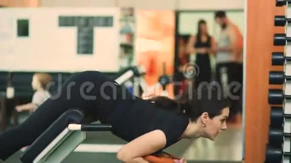 强壮的黑发女人在健身俱乐部做运动视频的预览图