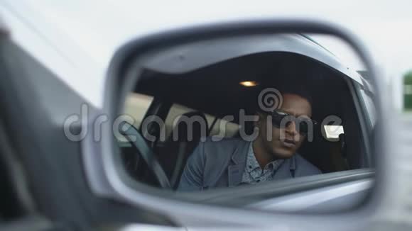 坐在车内的警察侧镜中的反射并用dslr摄像机拍摄视频的预览图