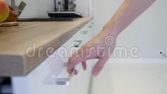 一个白色厨房橱柜的女人手打开抽屉视频的预览图