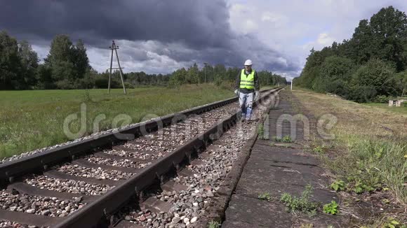 铁路工人带着手机和可调节扳手在铁路附近慢动作行走视频的预览图