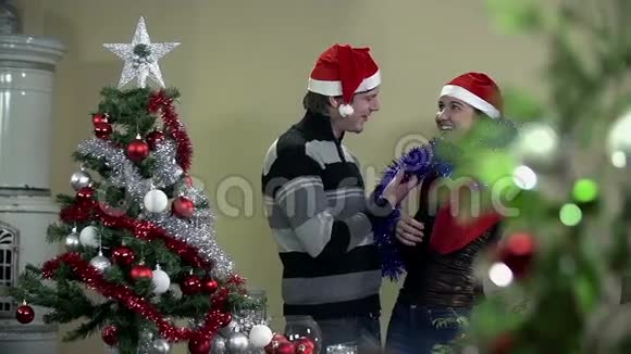 一对正在装饰圣诞树的情侣视频的预览图