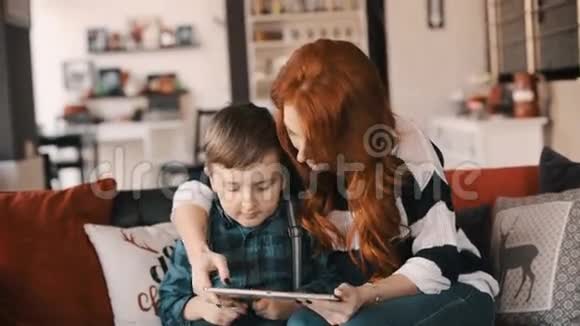 年轻的母子享受平板电脑视频的预览图