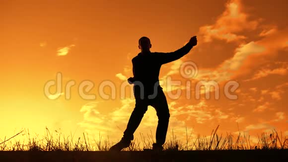 一个男人在日落时滑稽地跳舞的剪影有趣的人笑跳舞娱乐生活视频的预览图