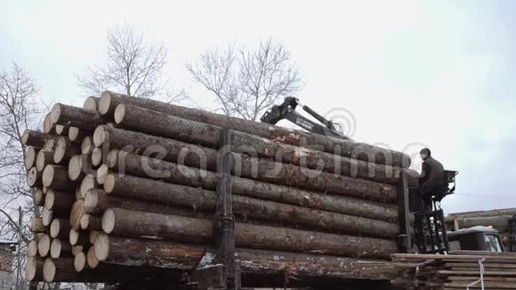 重型装载机在锯木厂生产时从重型卡车上卸下木材视频的预览图