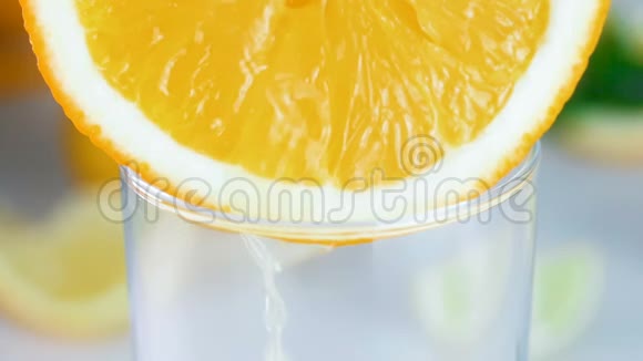 新鲜果汁从玻璃中的橙片中流出的宏观慢镜头视频的预览图