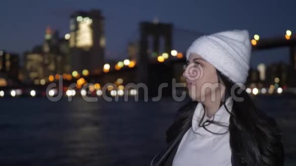 年轻女子夜晚欣赏曼哈顿天际线上美妙的景色视频的预览图