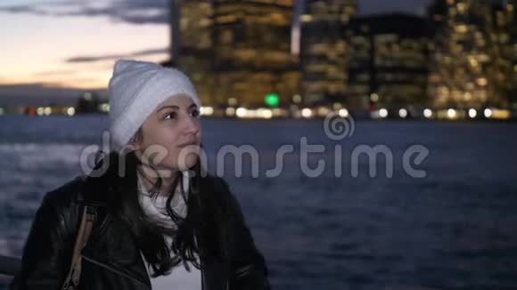 年轻女子夜晚欣赏曼哈顿天际线上美妙的景色视频的预览图