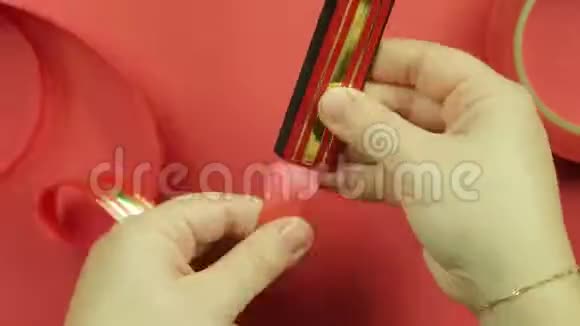 在红色背景上做一个红色丝带的礼物蝴蝶结时间跨度视频的预览图