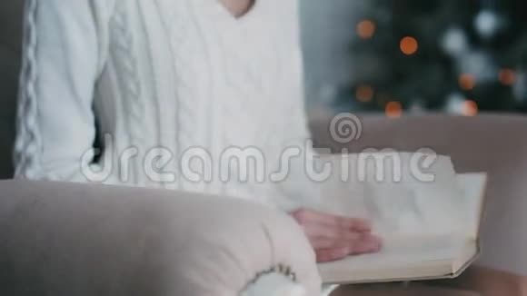 有书的美女坐在圣诞树旁视频的预览图