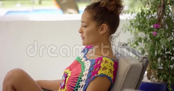 微笑的女人坐在五颜六色的椅子上视频的预览图