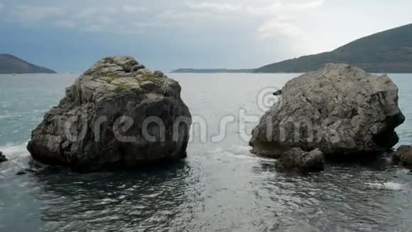 海浪拍打黑山海滩上的岩石视频的预览图