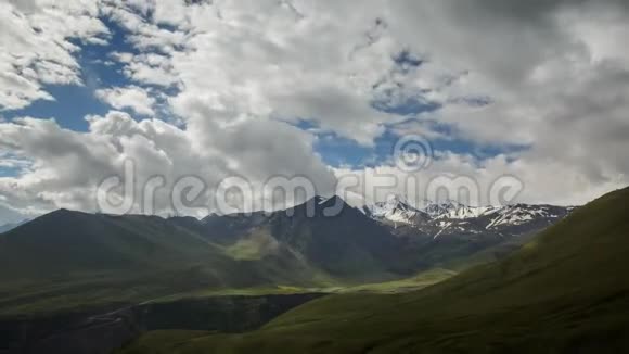 云在高加索山脉中缓缓游动夏天日出时绿冰相映的山峰阳光和阴影视频的预览图
