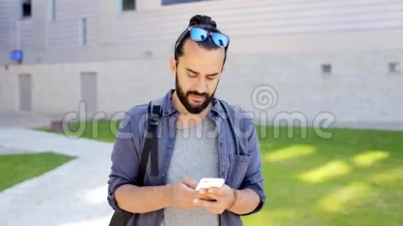 30岁的男子背包在智能手机上发短信视频的预览图