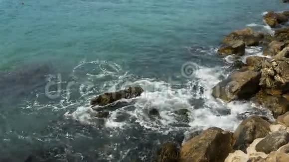 海浪拍打黑山海滩上的岩石视频的预览图