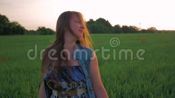 日落时分美丽的年轻女子在田野里跳舞慢动作视频的预览图