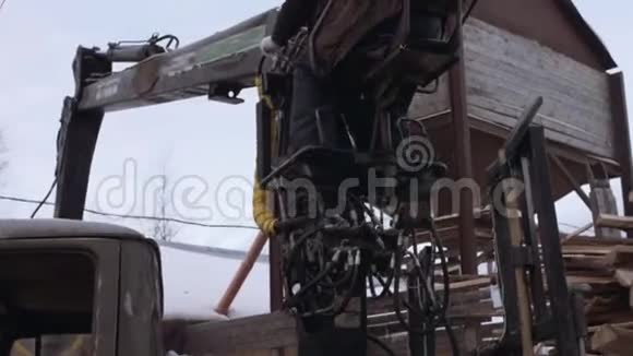 卡车爪式装载机在锯木厂从重型卡车上卸下木材废料视频的预览图