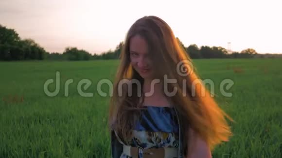 日落时分美丽的年轻女子在田野里跳舞慢动作视频的预览图