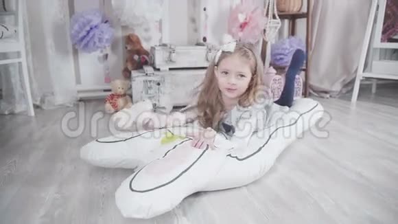 小可爱的女孩玩大软玩具兔子枕头玩具视频的预览图