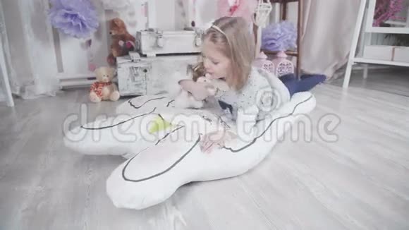 小可爱的女孩玩毛绒玩具和大软玩具兔子视频的预览图