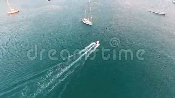 相机跟随充气摩托艇在小岛附近的帆船之间高清空中日落时间拍摄泰国视频的预览图
