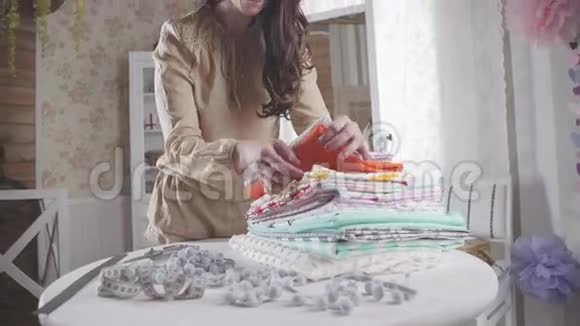 女人穿过一堆织物选择合适的图案视频的预览图