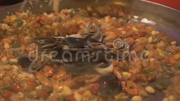 烹饪准备西班牙海鲜饭与米饭和新鲜海鲜在锅里关闭带有贻贝的传统西班牙菜饭视频的预览图