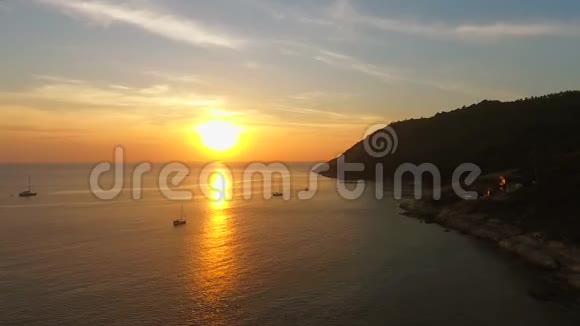 小帆船和游艇对抗阳光拍摄背景下的日落高清空中镜头泰国普吉岛视频的预览图